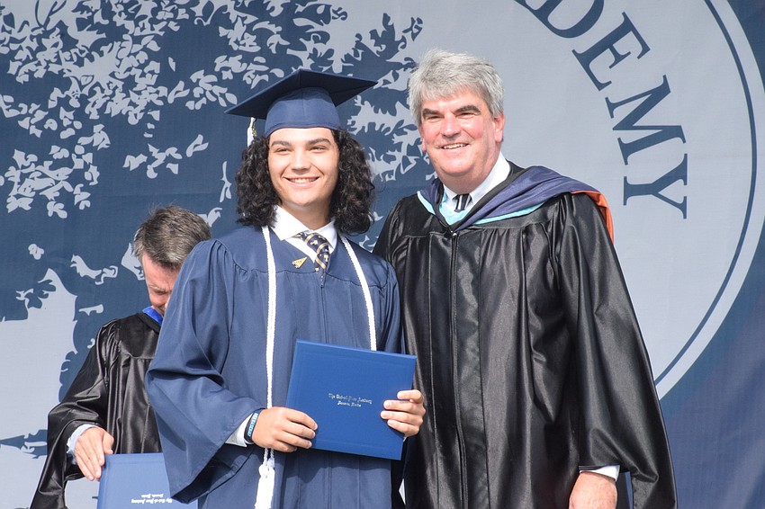 Graduate Tyler Colditz is congratulated by David Mahler, the head of school.