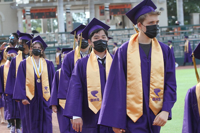More than 200 students walk to their seats at Ed Smith Stadium.