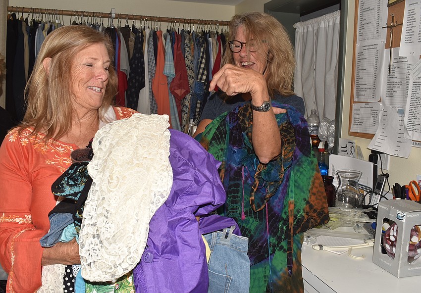Virginia Luke and Shelly Harrison discuss whether to donate, leave it to the Warehouse or keep it for their closets.