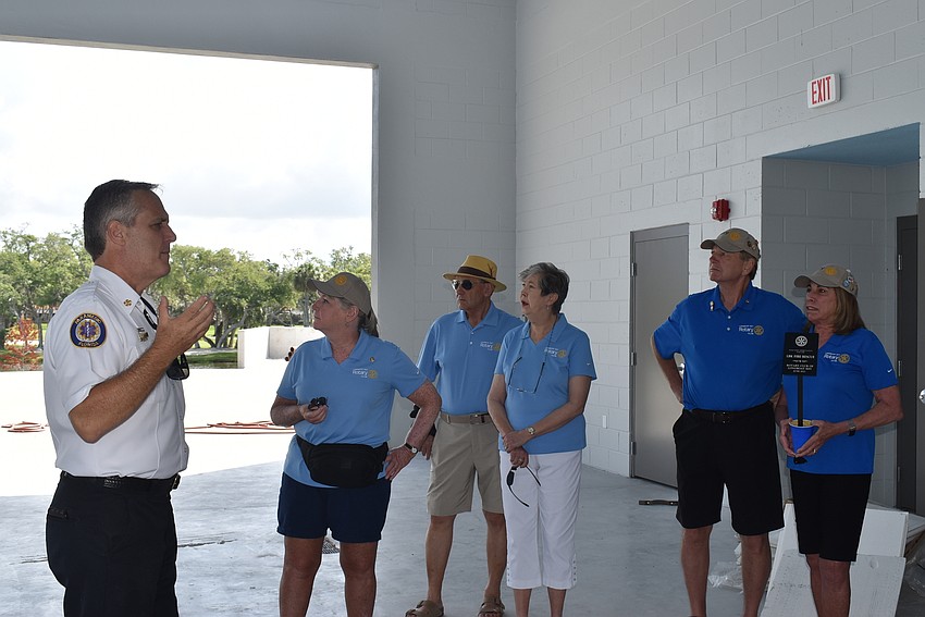 Fire chief Paul Dezzi, left, explains that the blue color of the ceiling helps fend off mud daubers, which like the high ceilings of fire stations.