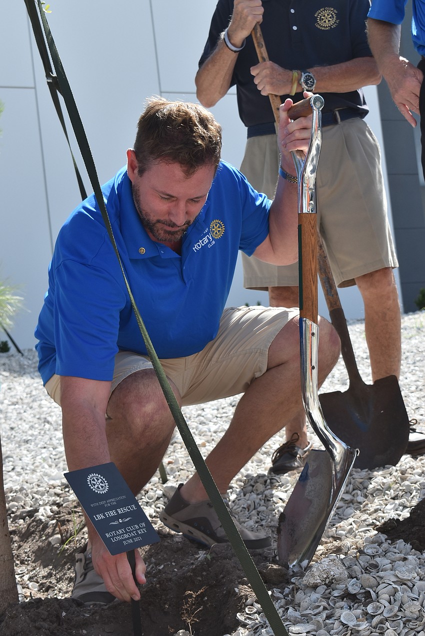 Bo Fuller nestles the plaque into the ground.