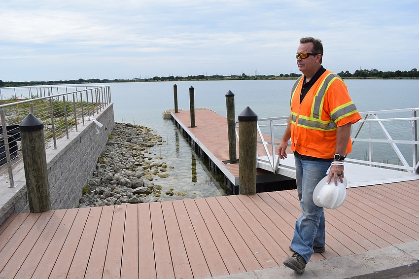 Jason Rinard stands with the floating dock behind him that will serve as a launching point at the marina for kayaks and water taxis.