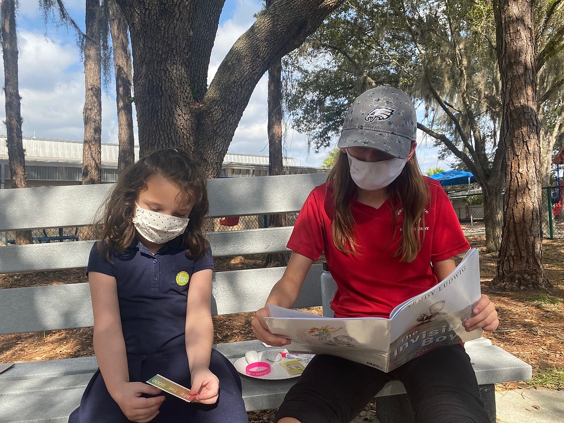 Braden River Elementary School first grader Jordan McCarte listens intently as her reading buddy, Gia Giangrante, who is a fifth grader, reads "The Invisible Boy." Courtesy photo.