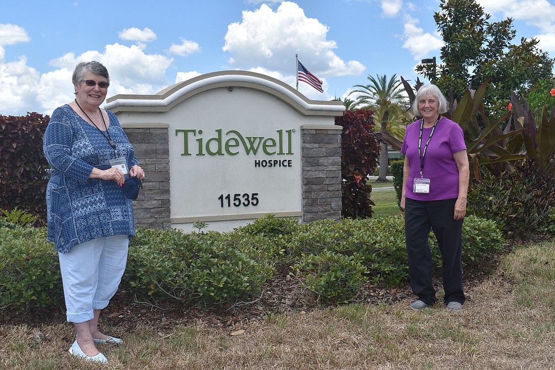 Tidewell volunteers Lynda Anderson, who works in patient support, and Phyllis Scarff, who works as a host, stand outside the entrance to the Lakewood Ranch facility. Anderson couldn&#39;t do patient support for more than a year.