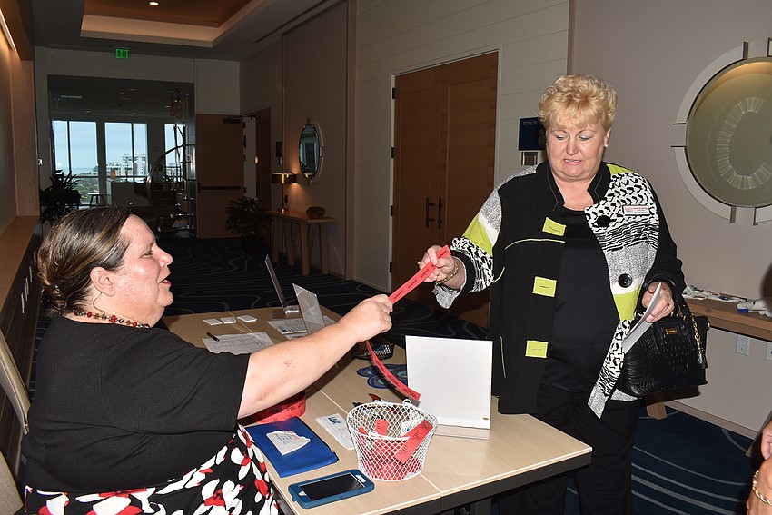 Christine Rothberg hands Marla Leung her raffle tickets.