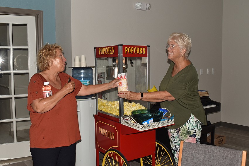 Sandi Love grabs popcorn from Donna Sharp-Blaney.