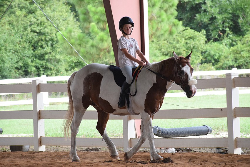 Kamila Rencher, who is 10, takes Gracie on a walk around the arena.