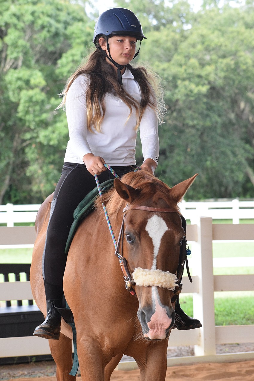 Isabella Hackett, who is 11, says she loves coming to camp because she can see the horses whenever she wants.