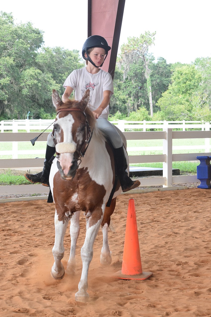 Kamila Rencher, who is 10, guides Gracie around a corner in a canter.