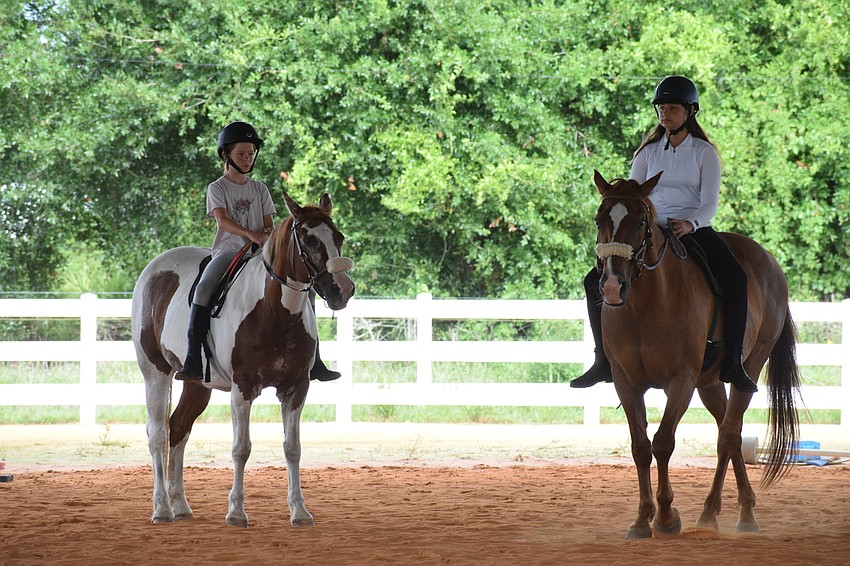 Kamile Rencher, who is 10, and Isabella Hackett, who is 11, listen to instructions before going through a barrel pattern.