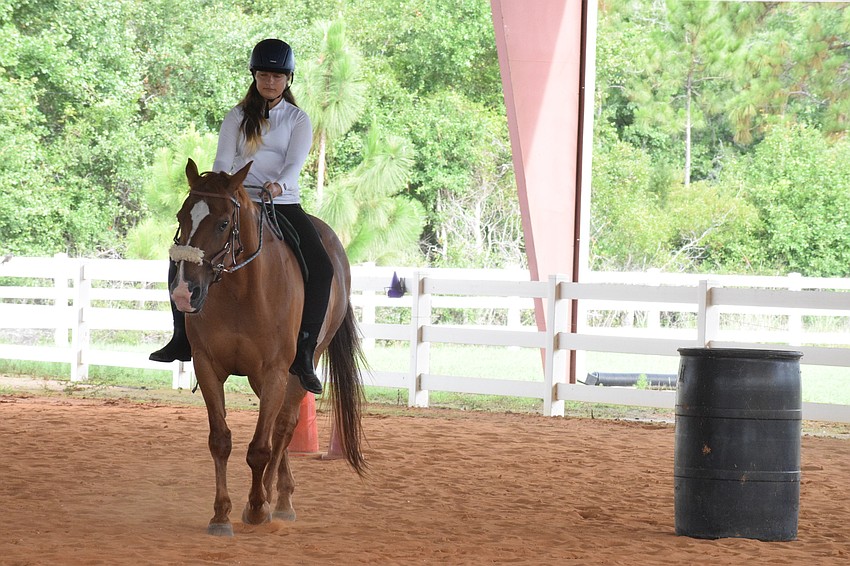 Isabella Hackett, who is 11, guides Cherokee around a barrel before moving toward the next barrel.