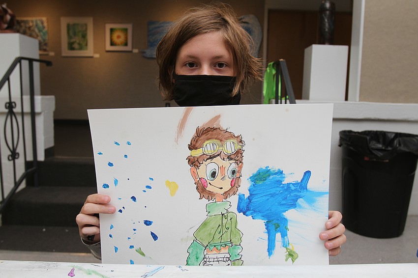 Amelie Roland, 10, draws a figure of his own design.