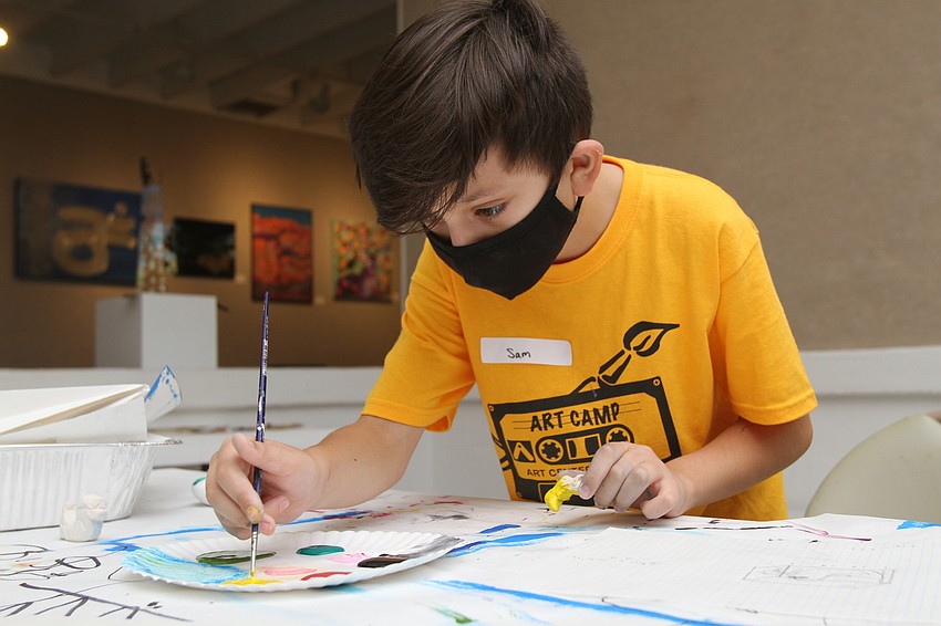 Sam Willner, 11, paints his duck yellow.