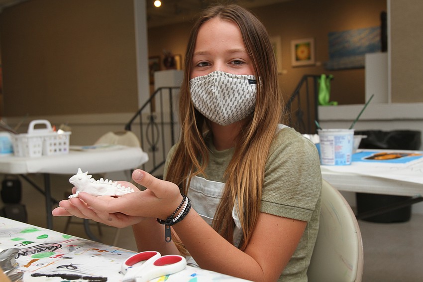 Chloe Cocozza, 10, proudly displays her dragon.