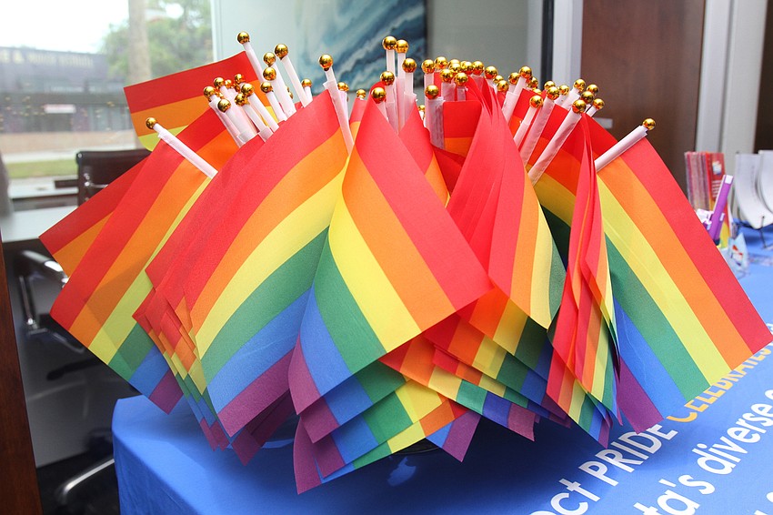 Project PRIDE staff pass out several flags.