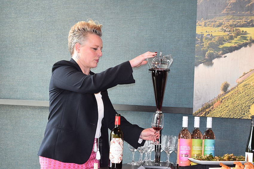 Cooper's Hawk Vice President Emily Wines pours a glass of wine from the decanter that is delivered to each patron who orders a bottle of wine.