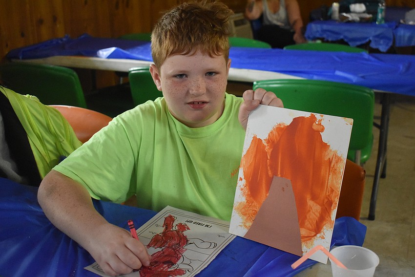 Corbin Stringer, 10, shows off his work during arts and crafts time. Stringer most enjoyed horseback riding and bonded with the horse he rode, Tank. Stringer said Tank was a 