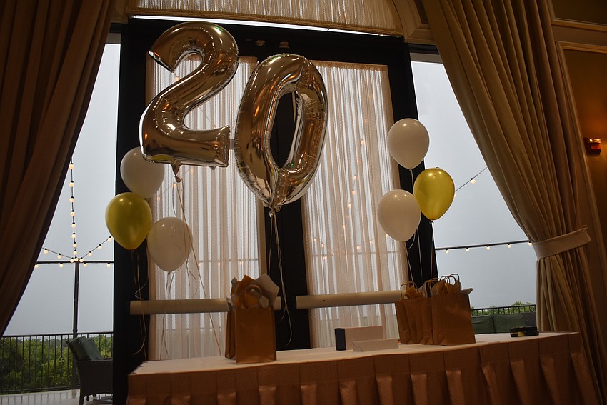 Balloons signifying the club's 20th birthday float above a table flanked with awards to be given out later in the night.