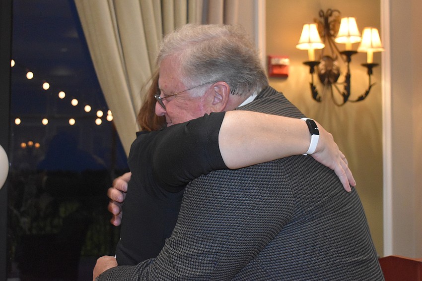 President Laura Adcock hugs Paul Oakes after the latter received the Service Above Self Award to a standing ovation.