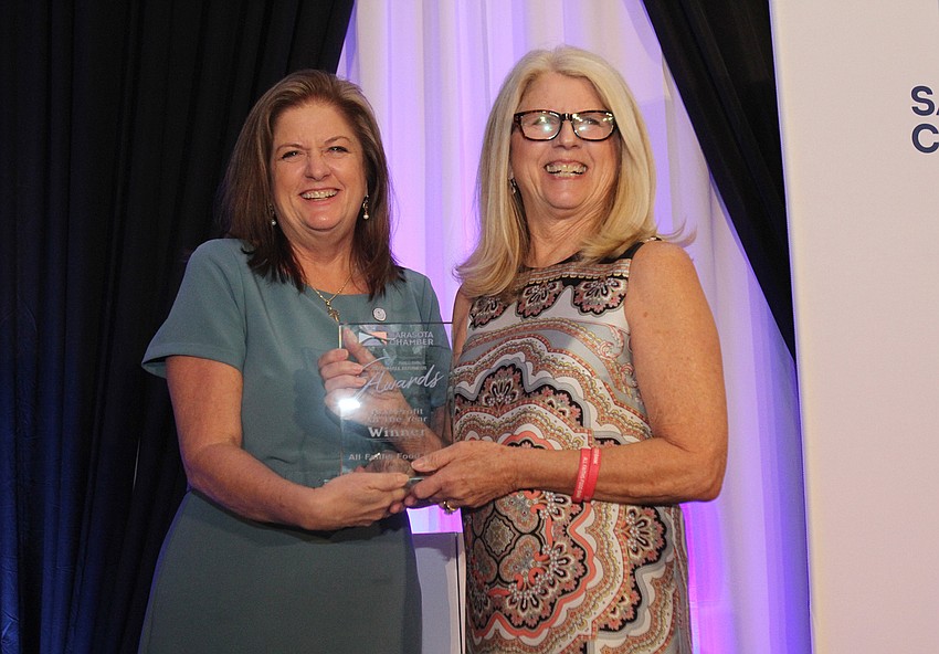 Maria Dmochowski hands the Non-Profit Organization of the Year award to Sandra Frank with All Faiths Food Bank.