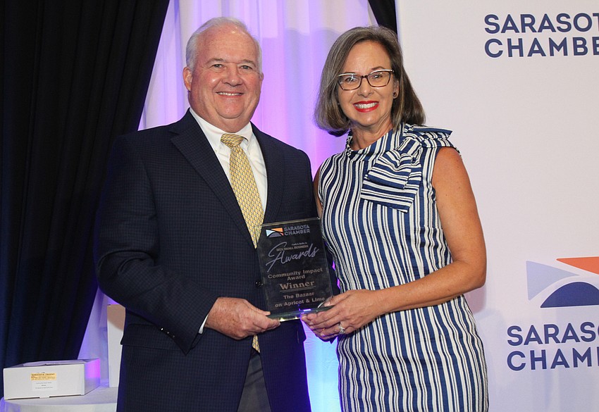 Rob Lane gives the Community Impact Award to Kim Livengood with The Bazaar on Apricot & Lime.