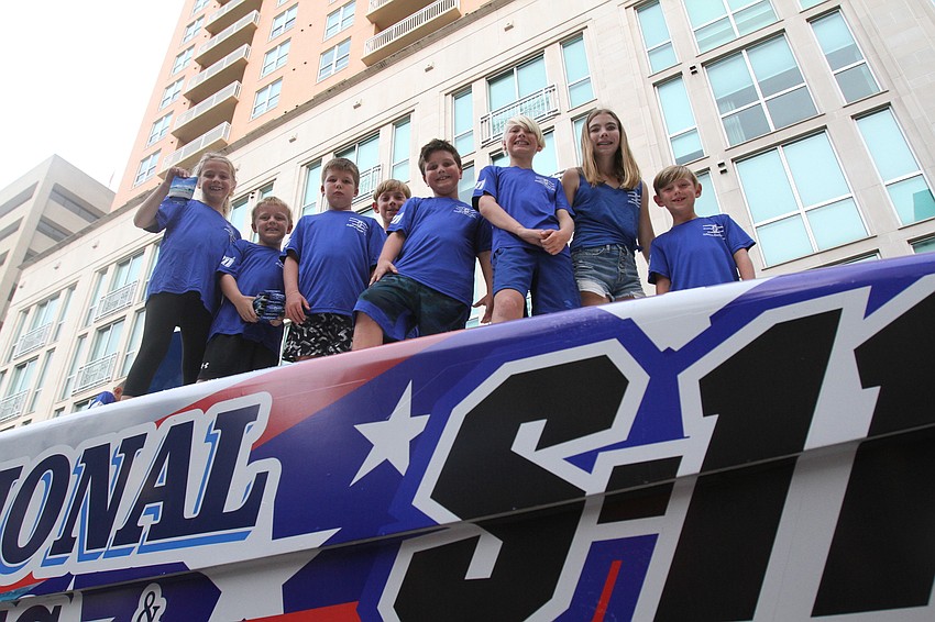 The Plumbing Professionals group pass out drink covers and other gifts from the boat.