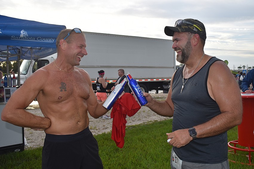Sarasota's Jim Lynn and Tony Peverini toast each other after finishing the four-mile race. Besides running, they enjoyed the smell of cookout foods nearby.