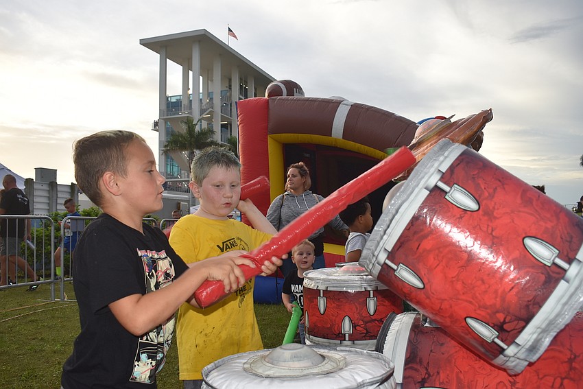 Sarasota resident Riley Gallagher, 7, Venice resident Connor Croce, 7, Sarasota resident Cameron Gallagher, 2, and Bradenton resident Andre McCloud, 4, play with an inflatable drum set in the Kids Zone.