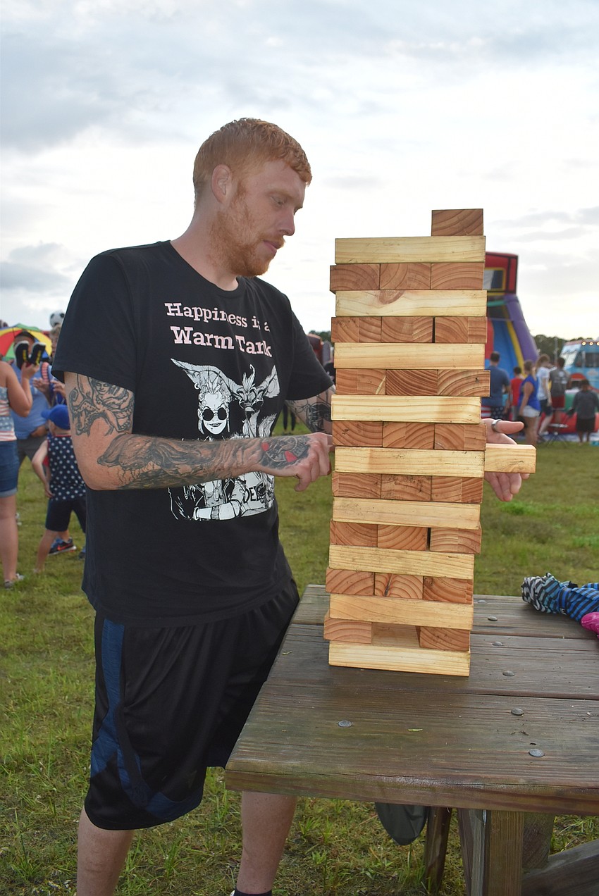 Bradenton resident Chauncey Leahy begins a game of Jenga. Besides the fireworks, his favorite part of the event was eating Chick-Fil-A.