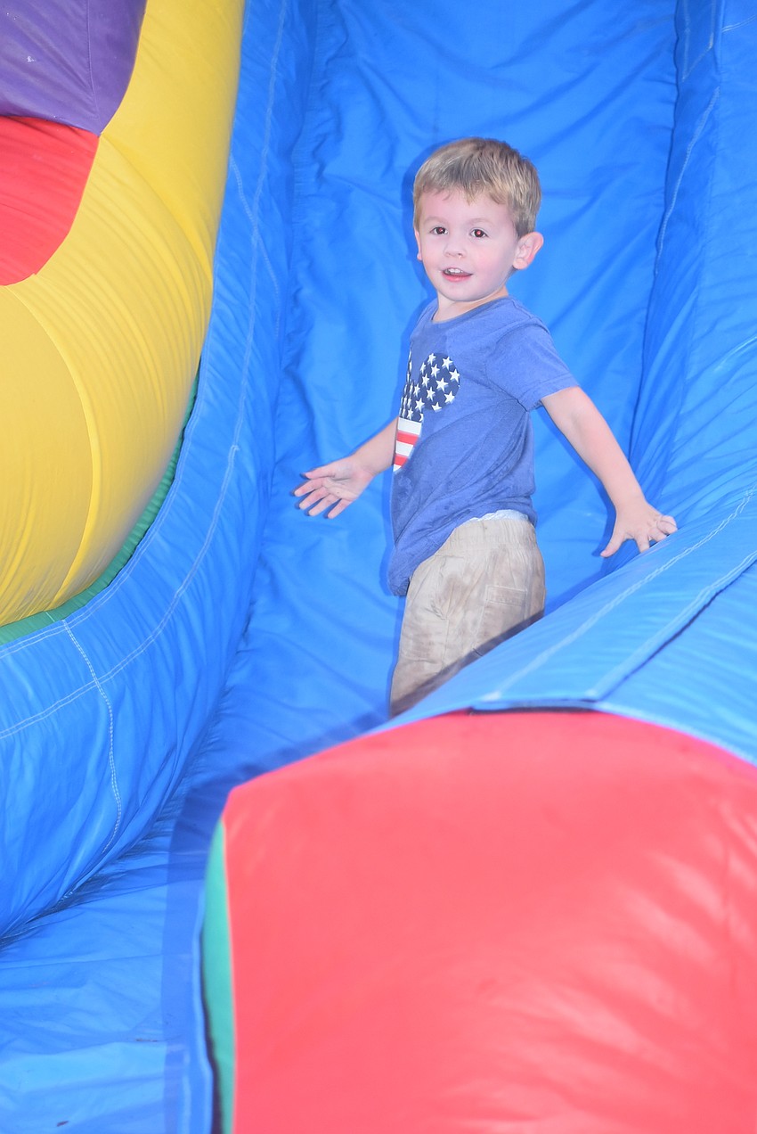Bradenton's Banks Gregory, 2, smiles after taking a tumble down an inflatable slide in the Kids Zone.