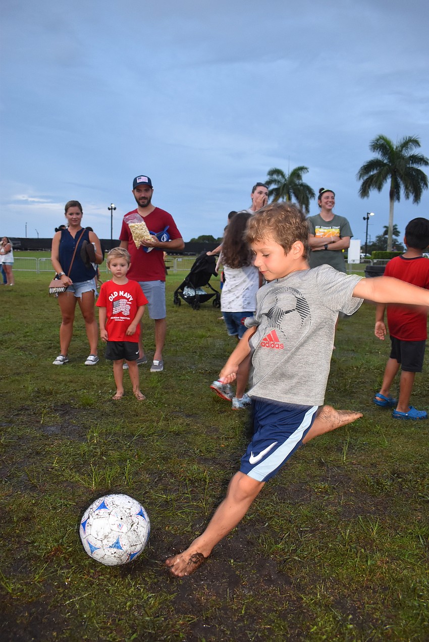 Greyhawk Landing's Anthony Esposito, 7, kicks a soccer ball as part of one of the games included in the Kids Zone. His favorite part of the night before the fireworks was the obstacle course.
