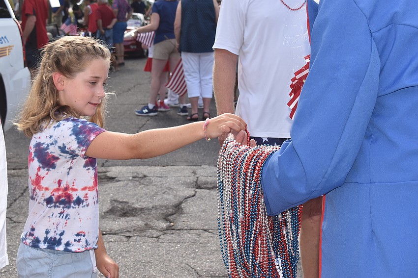 Phoebe Gallagher gets some beads from Jim Seaton