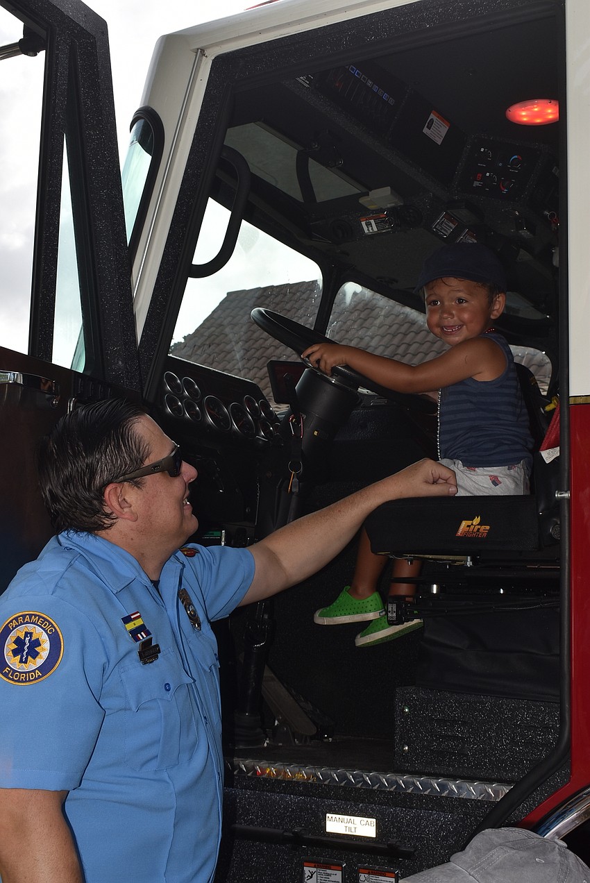 Firefighter Jason Berzoskie helped kids like Noah Kennedy into the fire truck.
