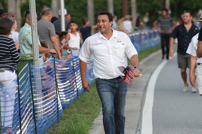 Mayor Hagen Brody passes out flags to families.