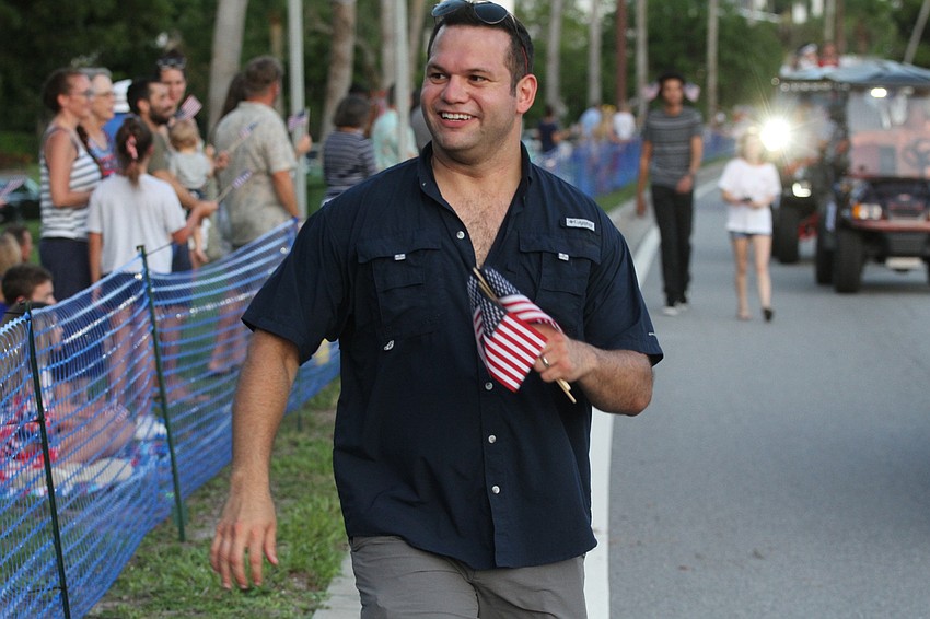 Vice Mayor Eric Arroyo passes out flags.