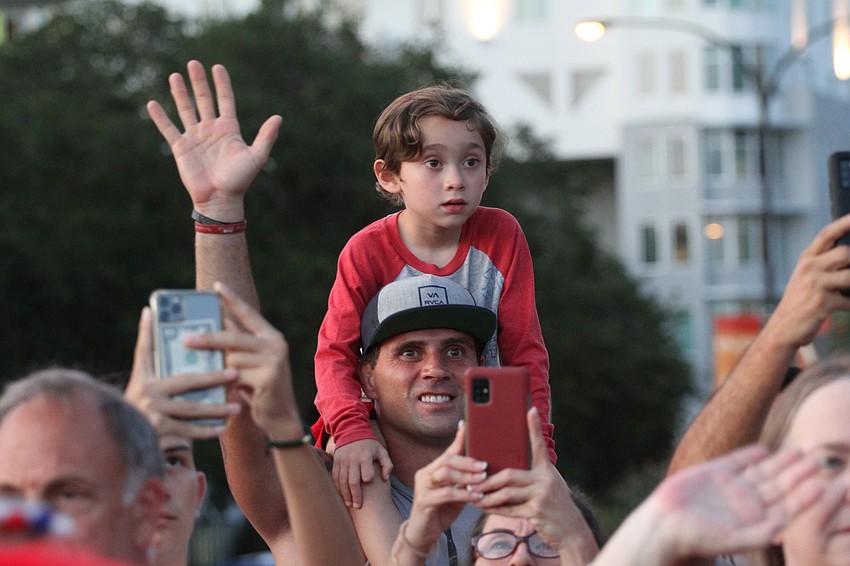 The crowd cheers on the parade.