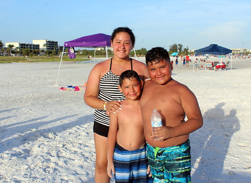 Sherlyn, Ronaldo and Raul Cornejo play in the sand before the display.