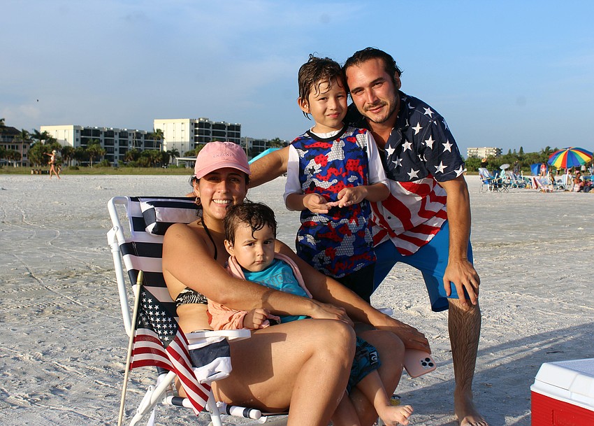 The Robayo and Medina families show off their patriotic garb as they celebrate on the beach.