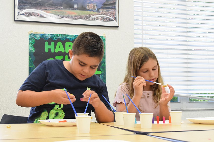 Mason Dennis and Allison Strausser focus on painting every part of their noodles.