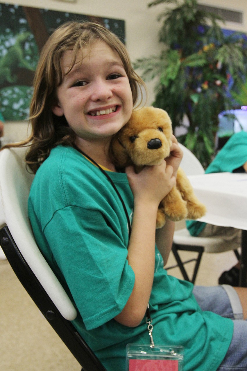 Summer Maule, 9, has fun with her dog plushie.