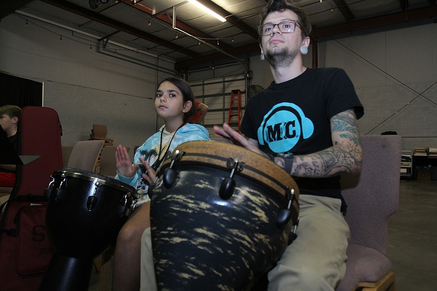 Romi Lardin, 9, and instructor Kyle Youmans play from the seats.