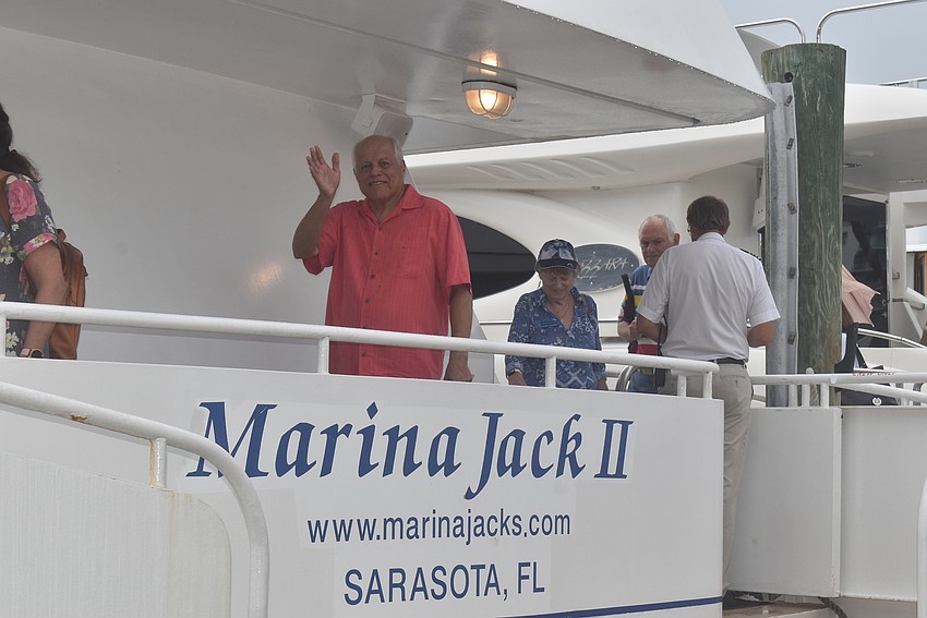 Dino Sifuentes waves as he boards the Marina Jack II.