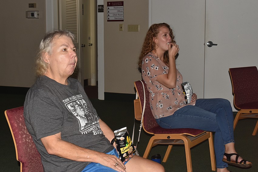 Laurie Merson and Nina Vannucci snack on popcorn before the movie starts.