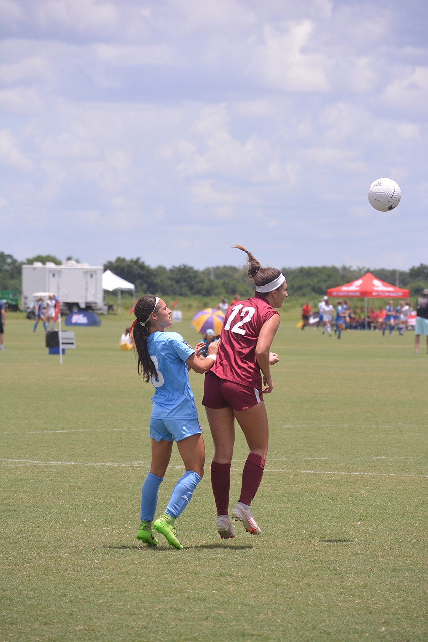 Madison Smith heads a ball out of danger.