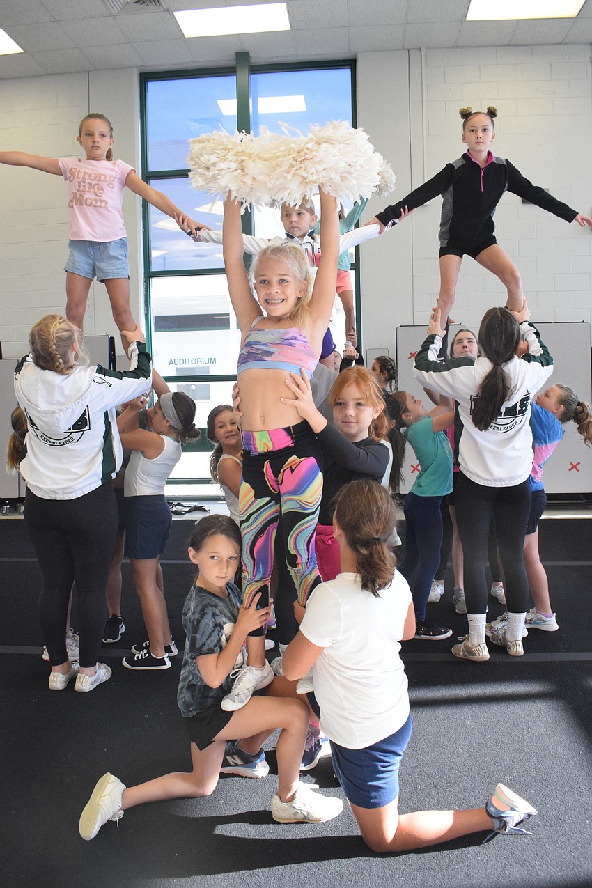 Campers practice stunting with the help of Lakewood Ranch High School varsity cheerleaders.