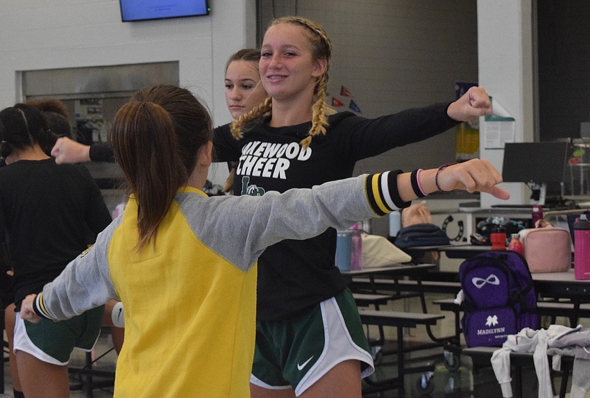 Alexandra Mahiquez, who is 10, looks to Chloe Wetherington, a JV cheerleader for Lakewood Ranch High School, for the next move in a cheer.