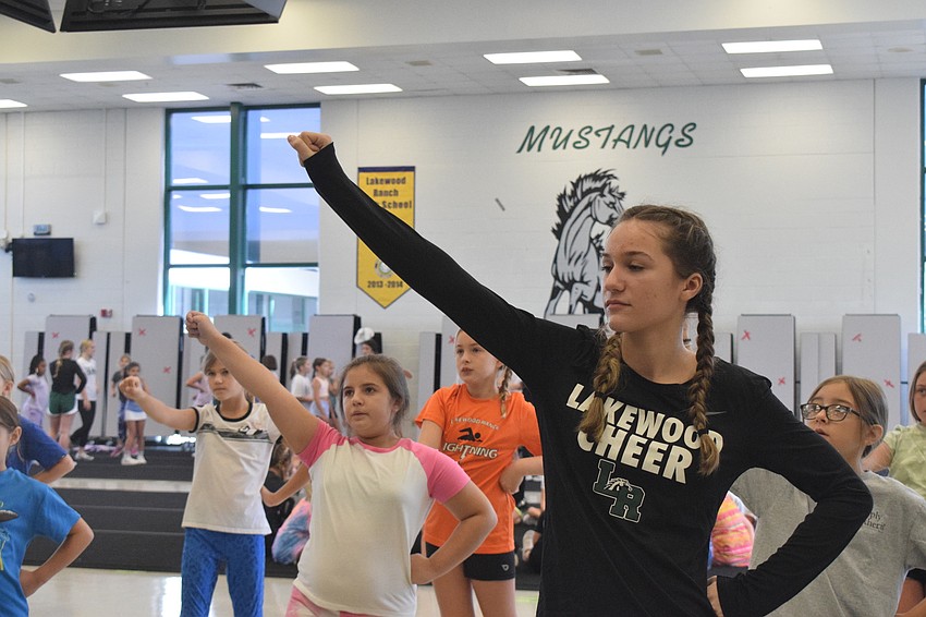 Emma Bogucki, Kiyanna Leonard and Cora Kovatch follow Lakewood Ranch High School JV cheerleader Kennedy Viquerat while learning a cheer.