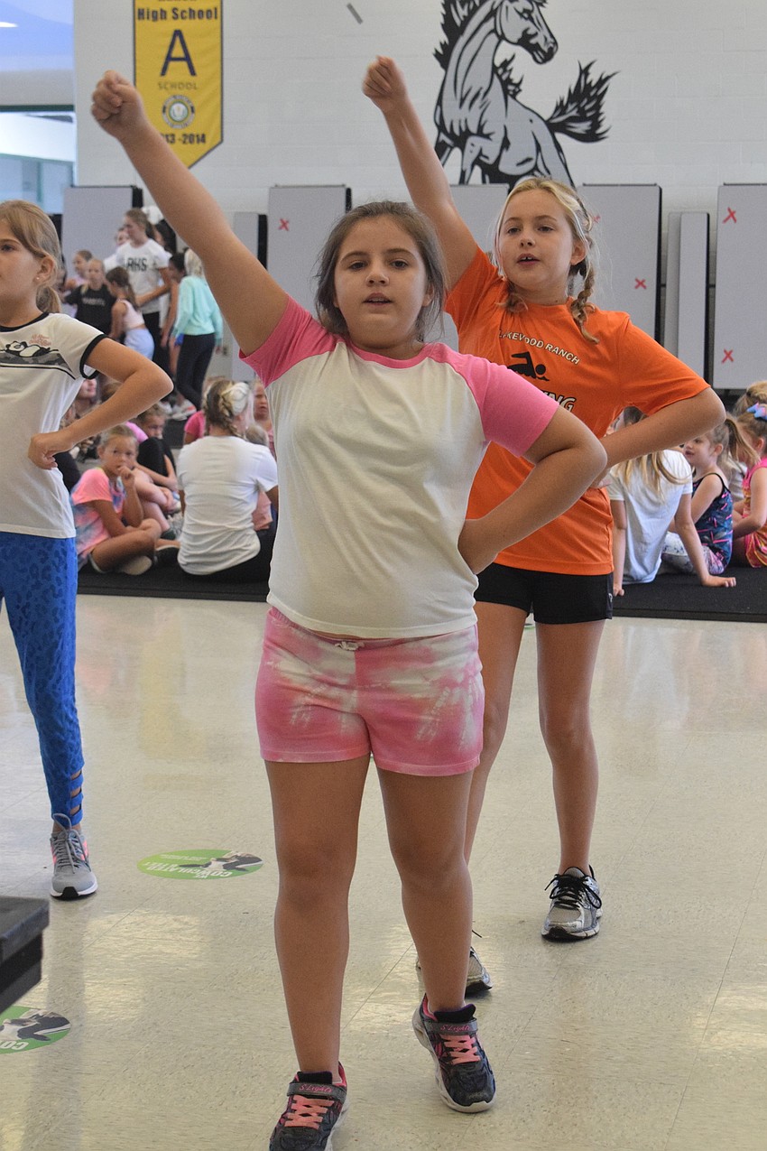 Kiyanna Leonard, who is 10, and Cora Kovatch, who is 10, practice a new cheer they learned.