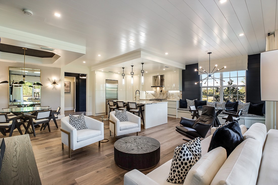 The living area features multiple seating and dining choices, brought together by a  strong black and white color scheme.