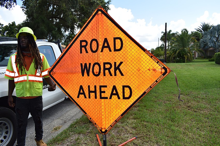 Southeastern Traffic Supply worker Xavier Wilson helped put up signage on July 22 for crews to remove poles on Birdie Lane.